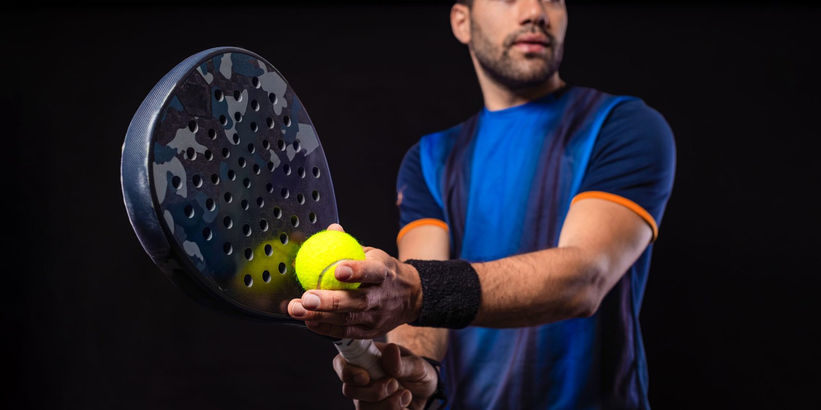 Padel tennis player with racket. Man athlete with paddle racket on black background. Sport concept. Download a high quality photo for sports website